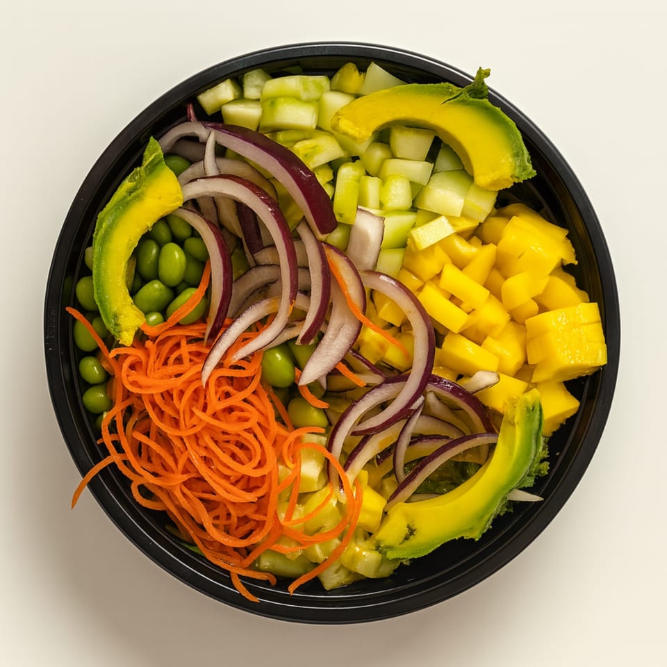 Overhead view of a Poke & Bubbles poke bowl with avocado, mango, cucumber, edamame, red onion, and carrots.