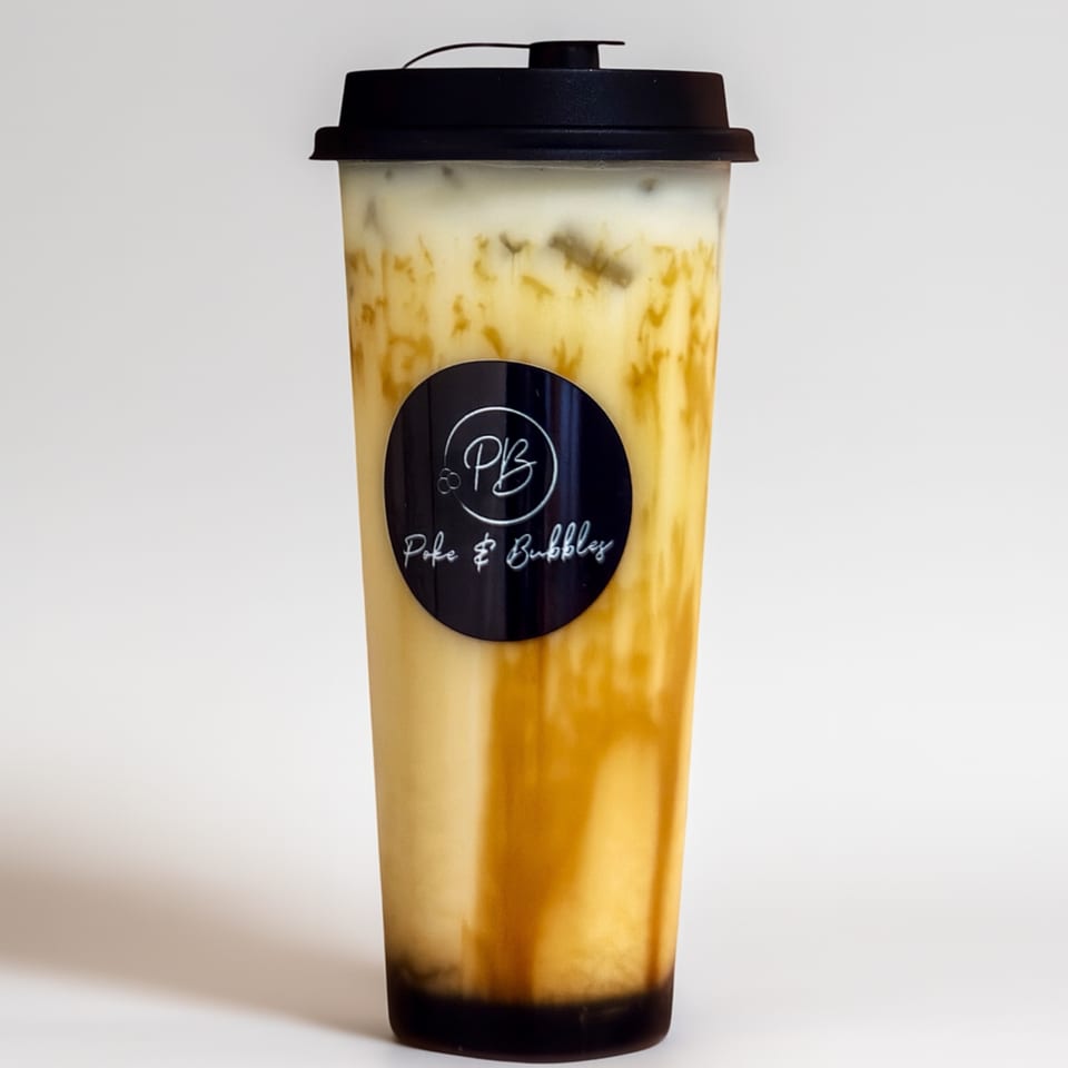 A tall plastic cup of Poke & Bubbles milk tea with brown sugar swirls and a black lid.